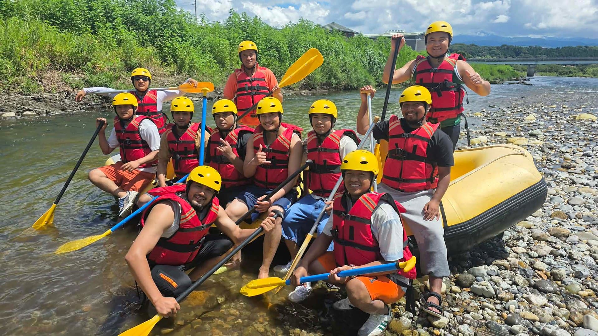 Dream Adventure rafting group with paddles at the riverside base