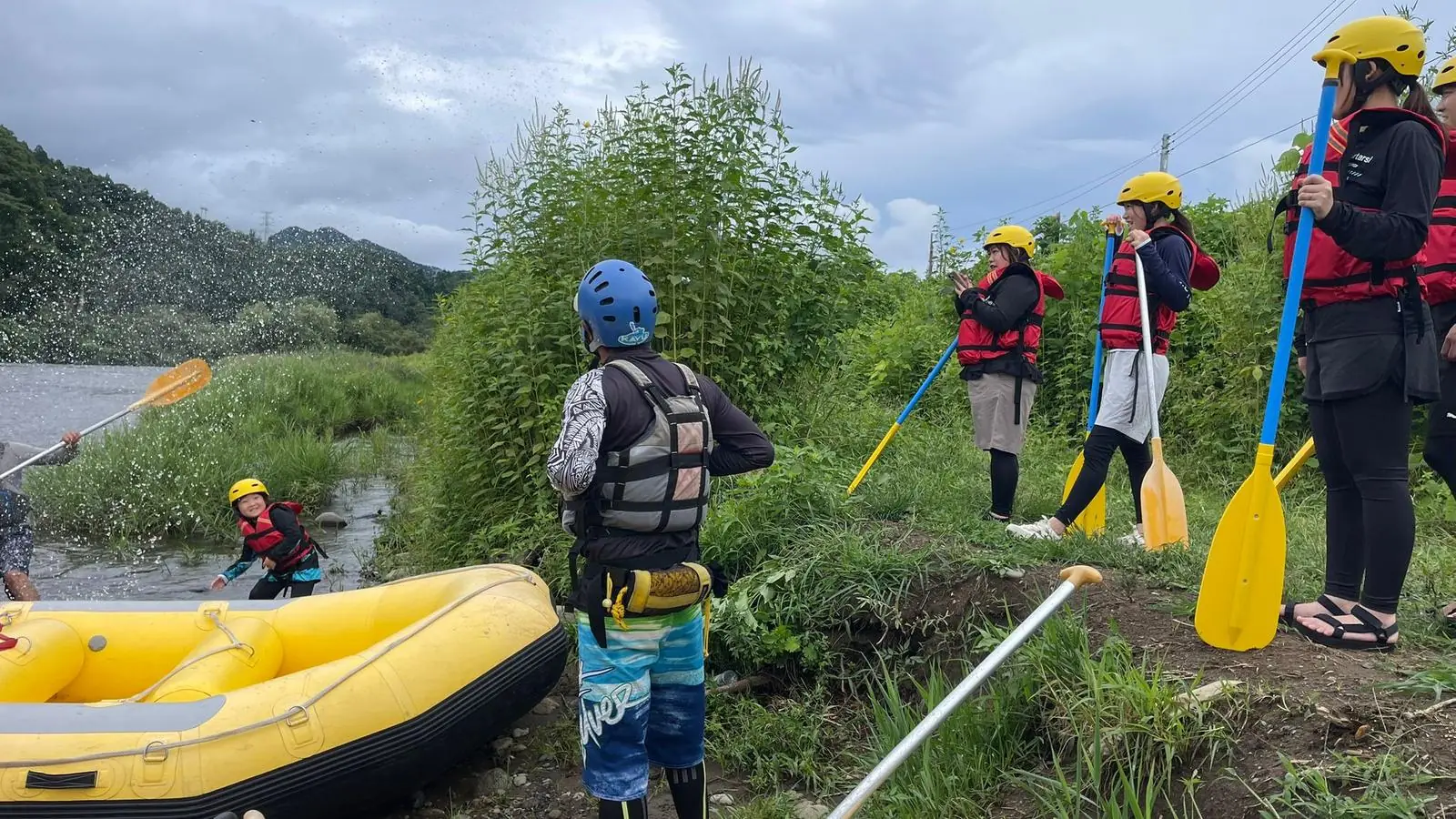 Dream Adventure guides and guests on the riverbank with paddles after a trip