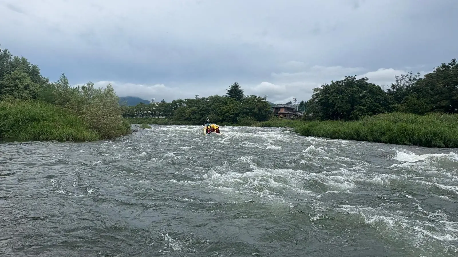 A wide view of the Tone River in Gunma with a raft in the distance