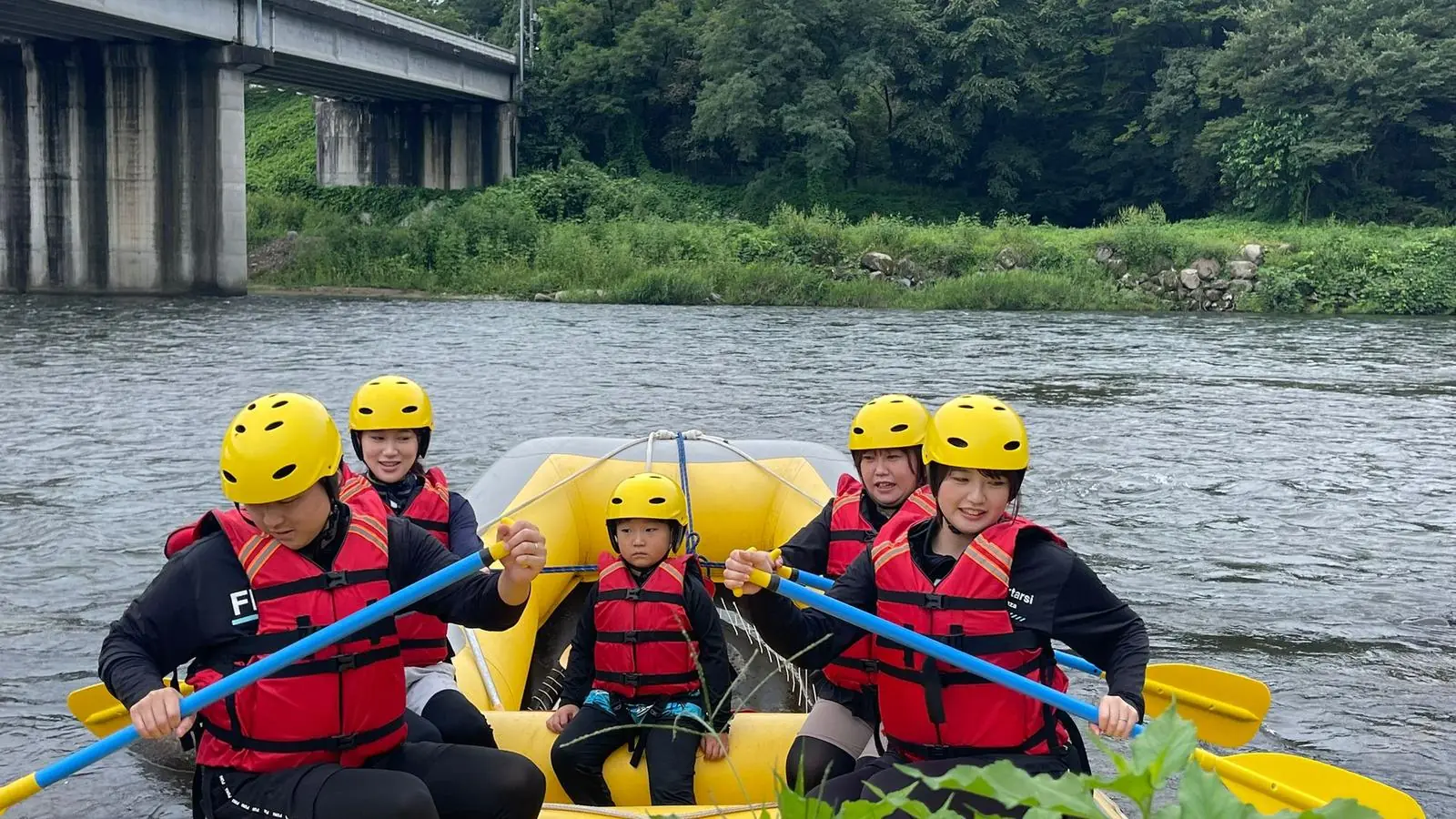 Guests smiling in a Dream Adventure raft on the Tone River